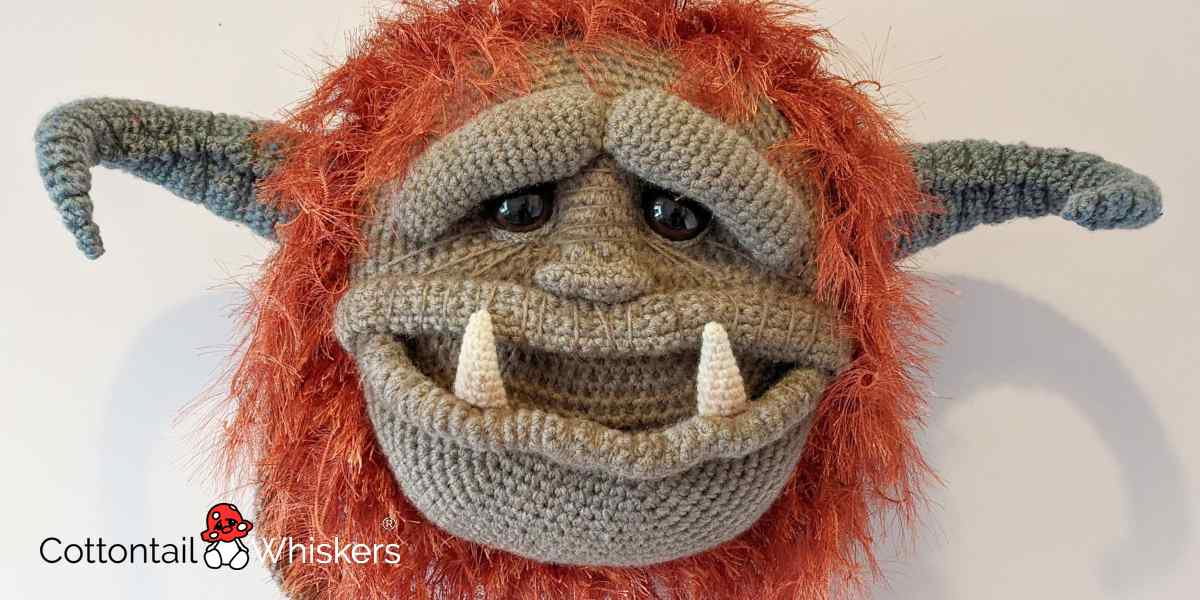 Huge shaggy Ludo Monster head with horns, all made as crocheted soft plushie cushions or wall hangings, created from an original design by Cottontail & Whiskers.